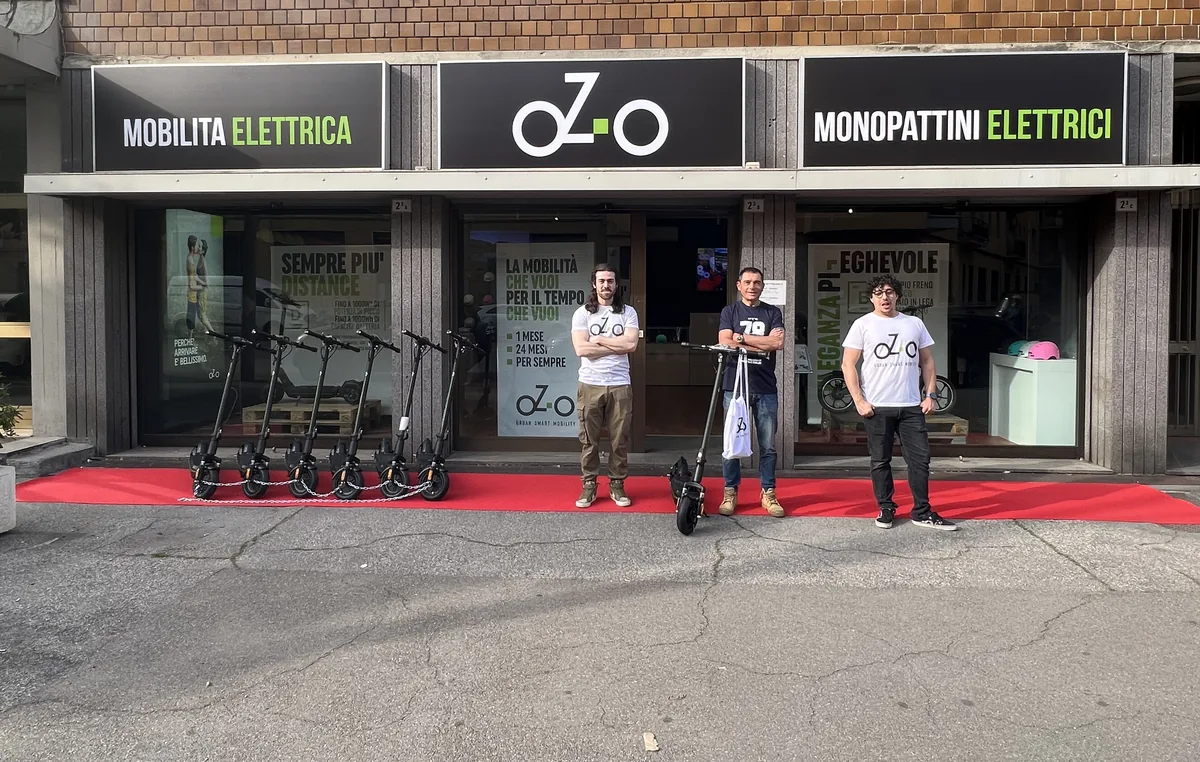 Mauro Sanchini al negozio pilota oZ-o di Bologna in via Amedeo Parmeggiani 2/3, con sei monopattini oZ-o D allineati su tappeto rosso